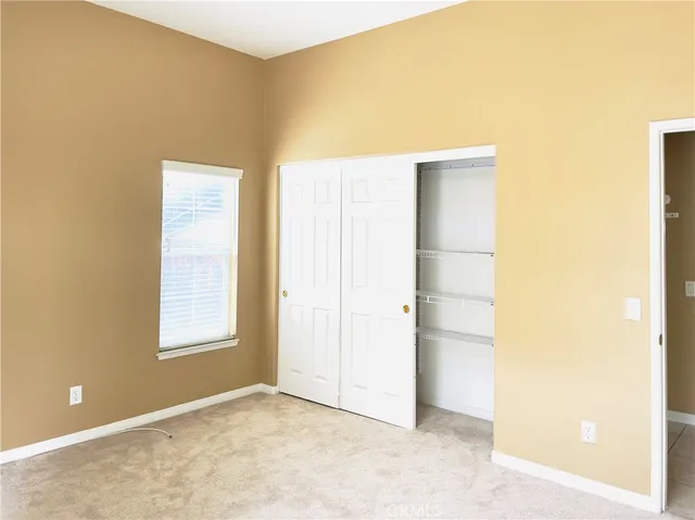 an empty room with windows and closet