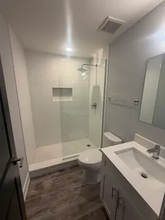 a bathroom with a sink a toilet and shower