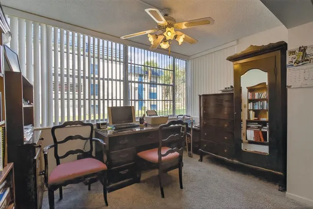 a view of a workspace with furniture and a book shelf