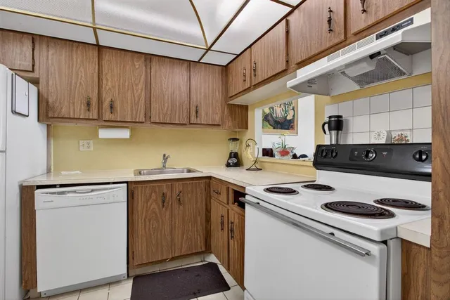 a kitchen with a refrigerator a sink and cabinets