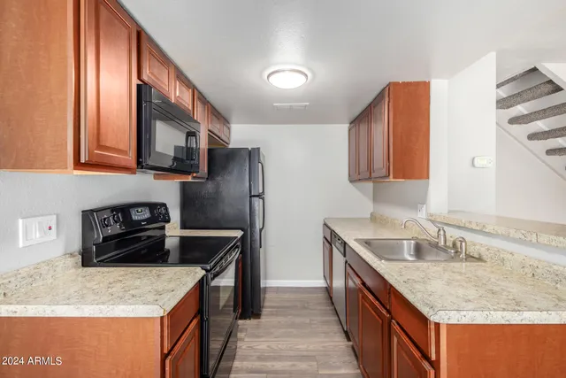 a kitchen with stainless steel appliances granite countertop a sink stove and refrigerator