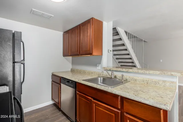 a kitchen with sink refrigerator and cabinets