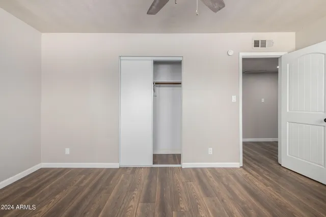 an empty room with wooden floor and closet