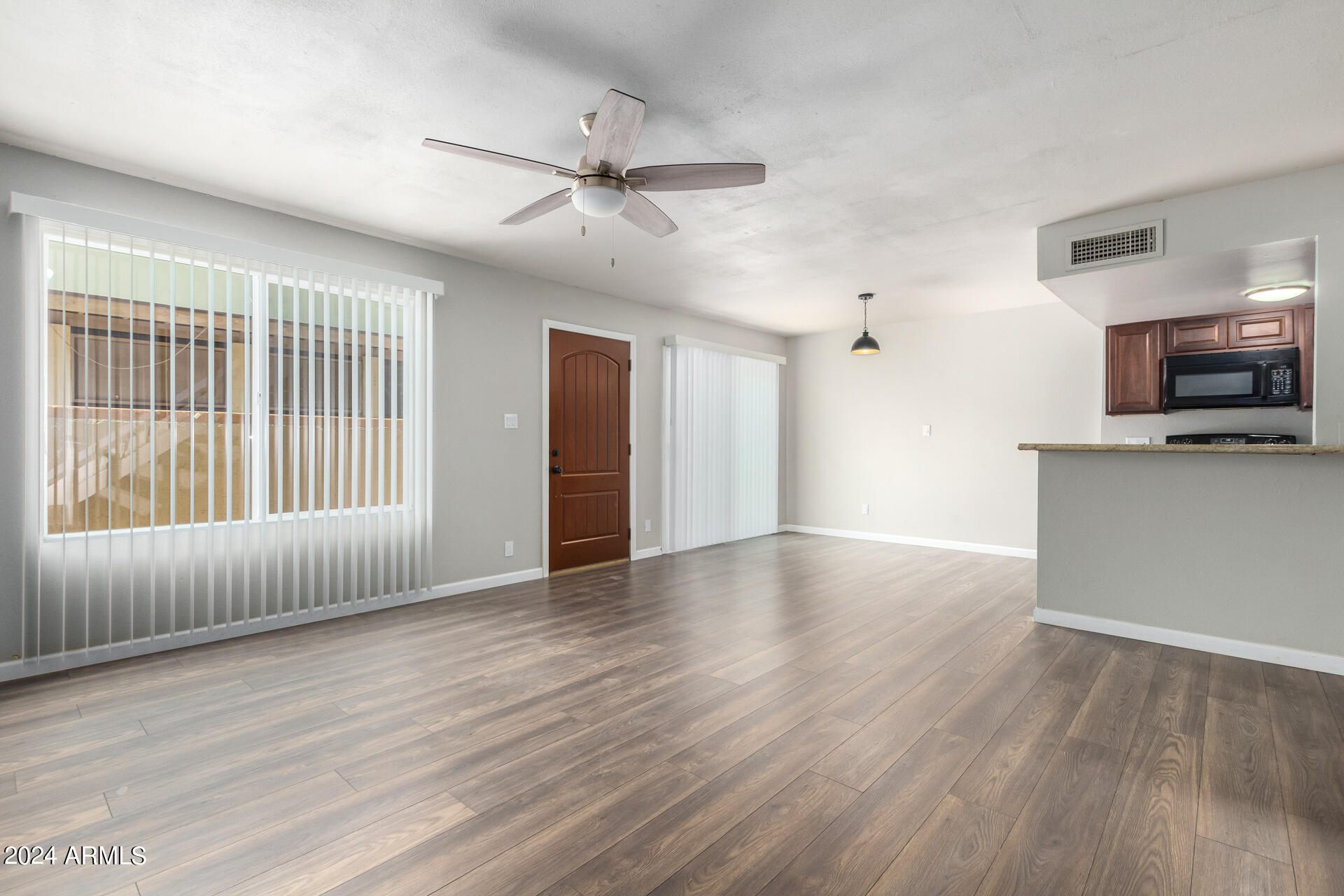 17034 East Calle Del Oro, Unit C Fountain Hills, AZ 85268 - Photo 7 of 22 a view of an empty room with wooden floor and a window