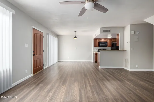a view of a kitchen with a sink cabinet a ceiling fan and wooden floor