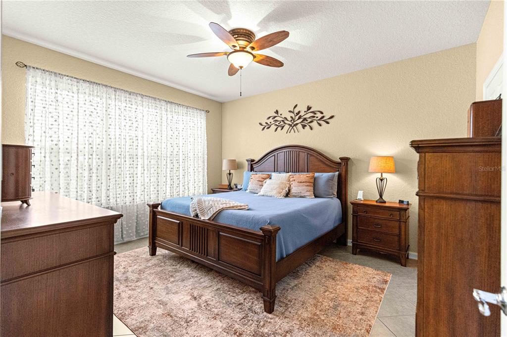 9566 Southwest 70th Loop Ocala, FL 34481 - Photo 19 of 53 a bedroom with a bed and a chandelier