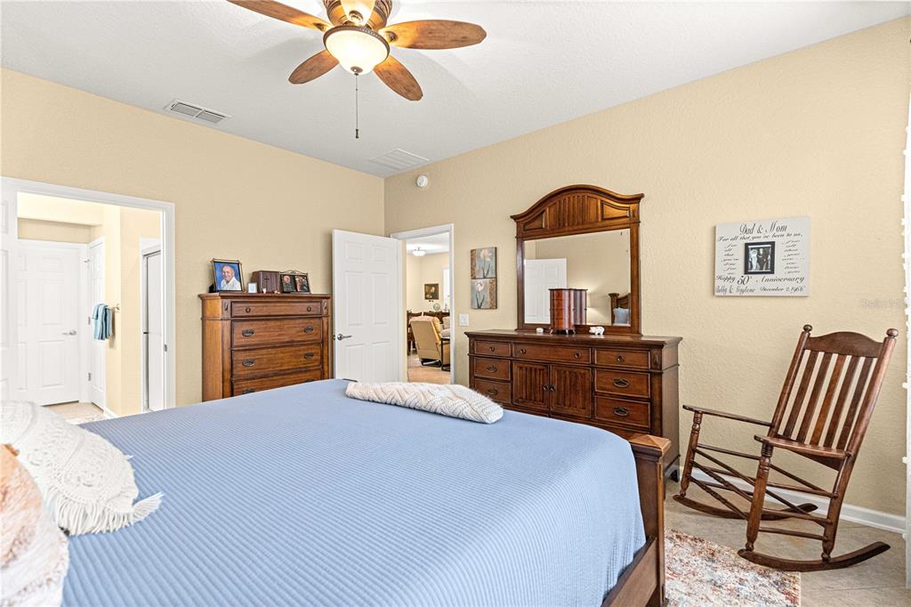 9566 Southwest 70th Loop Ocala, FL 34481 - Photo 20 of 53 a bedroom with a bed and a chandelier