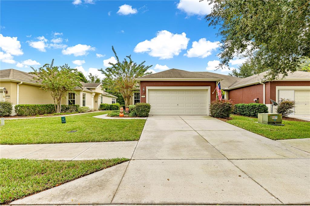 9566 Southwest 70th Loop Ocala, FL 34481 - Photo 2 of 53 a front view of a house with a yard and garage