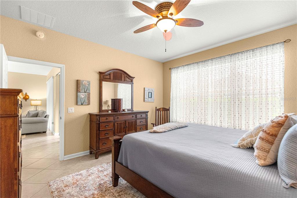 9566 Southwest 70th Loop Ocala, FL 34481 - Photo 21 of 53 a bedroom with a bed and a chandelier