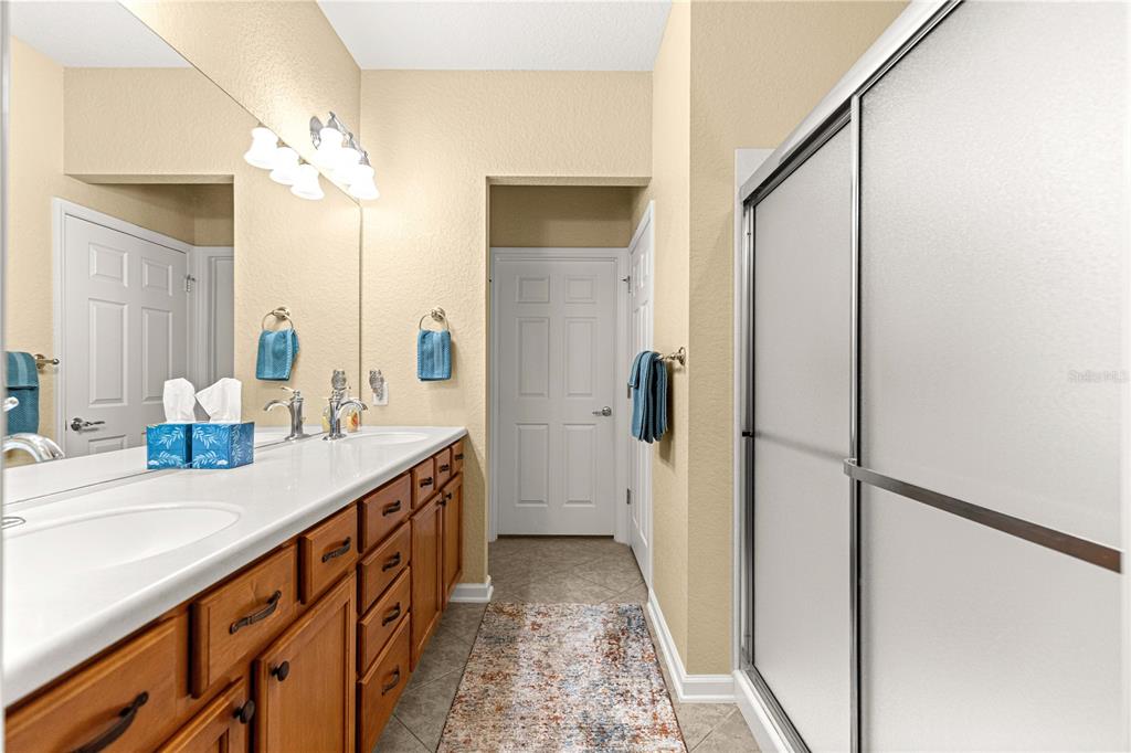 9566 Southwest 70th Loop Ocala, FL 34481 - Photo 24 of 53 a bathroom with a sink a mirror and a shower