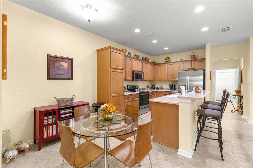 9566 Southwest 70th Loop Ocala, FL 34481 - Photo 6 of 53 a kitchen with a dining table chairs and refrigerator