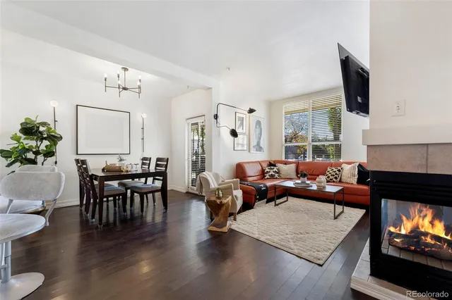 a living room with furniture a fireplace a flat screen tv and a large window