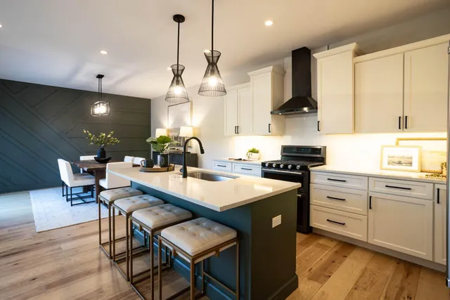 a large kitchen with stainless steel appliances a large center island attached withe living room