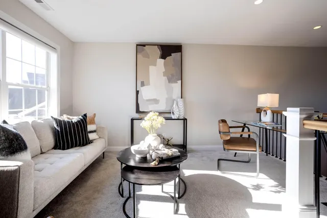 a living room with furniture and floor to ceiling windows