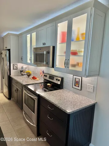 a bathroom with a granite countertop sink and a shower