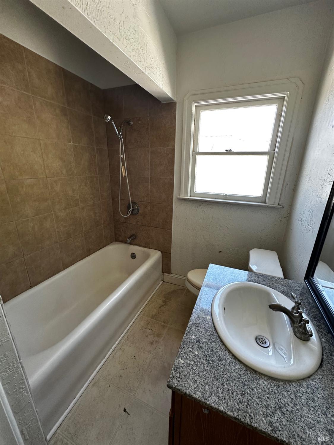 2015 Tennessee Street Vallejo, CA 94590 - Photo 10 of 29 a bathroom with a granite countertop sink a toilet and bathtub