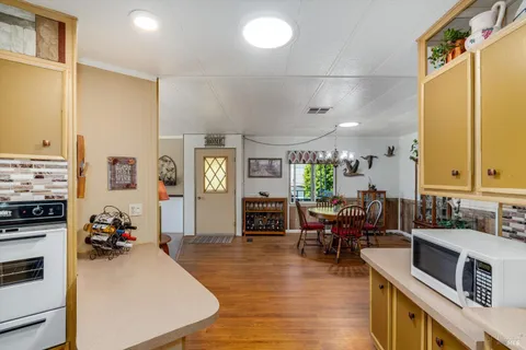 a living room with furniture kitchen view and a large window