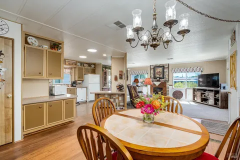 a view of a dining room with furniture a chandelier and wooden floor