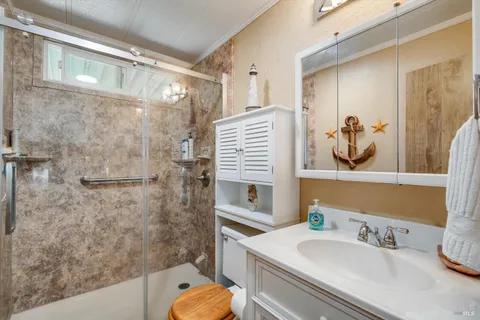 a bathroom with a granite countertop sink a toilet and shower