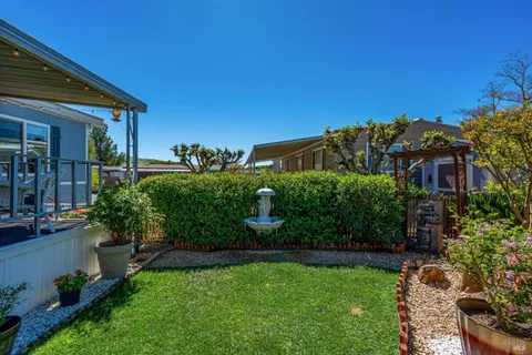 a view of a house with a yard and potted plants