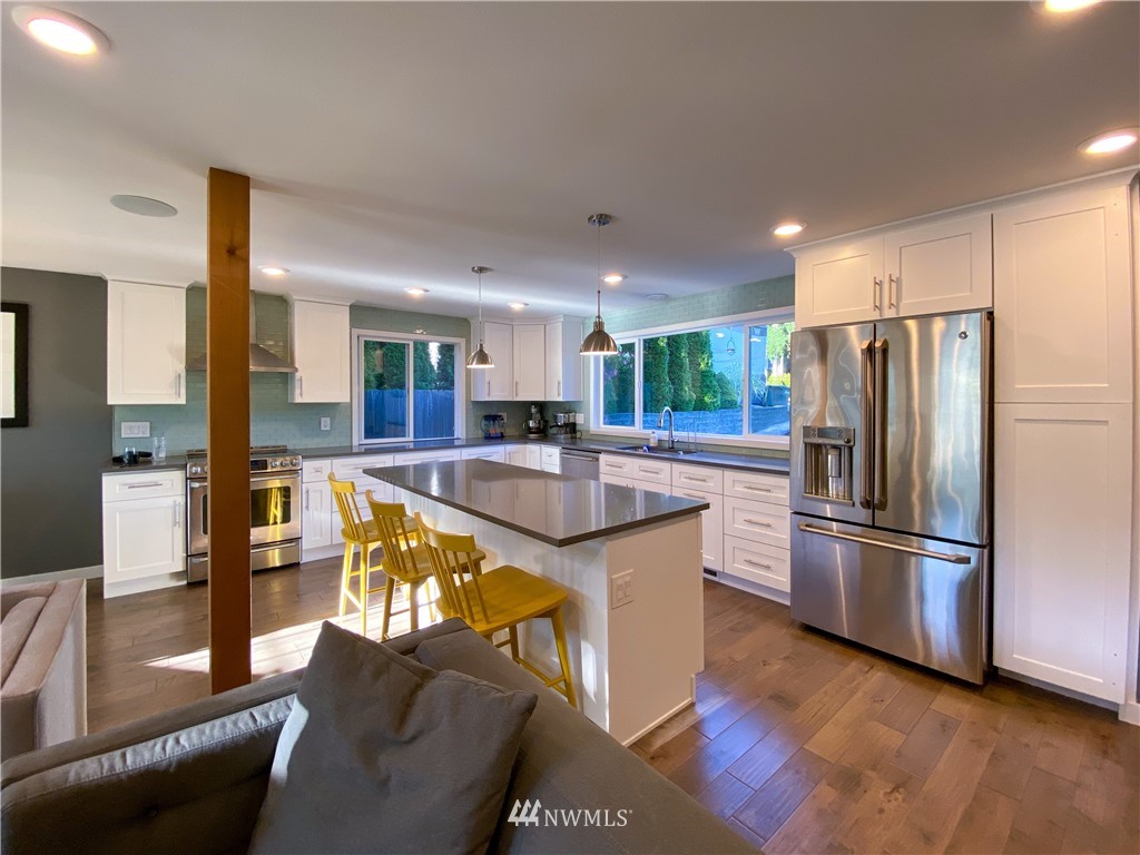 21904 1st Place West Bothell, WA 98021 - Photo 14 of 35 a kitchen with stainless steel appliances granite countertop a refrigerator a stove and a sink with wooden floor
