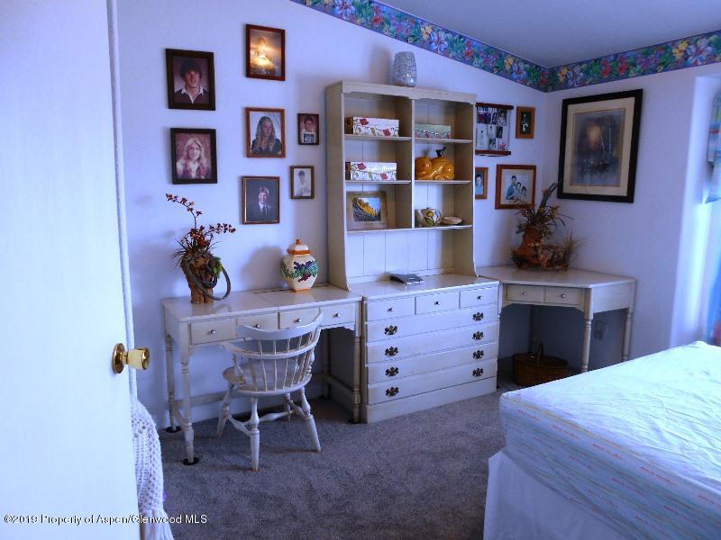 520 Lariat Road Silt, CO 81652 - Photo 23 of 30 a bedroom with a bed and a bookshelf