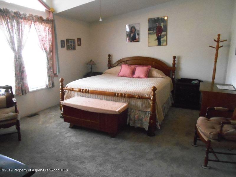 520 Lariat Road Silt, CO 81652 - Photo 27 of 30 a spacious bedroom with a bed and chair