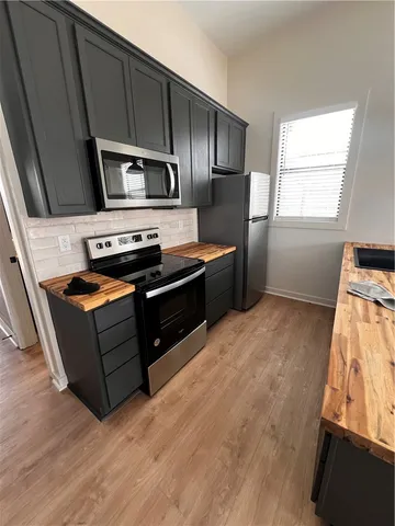 a kitchen with stainless steel appliances wooden cabinets and a stove