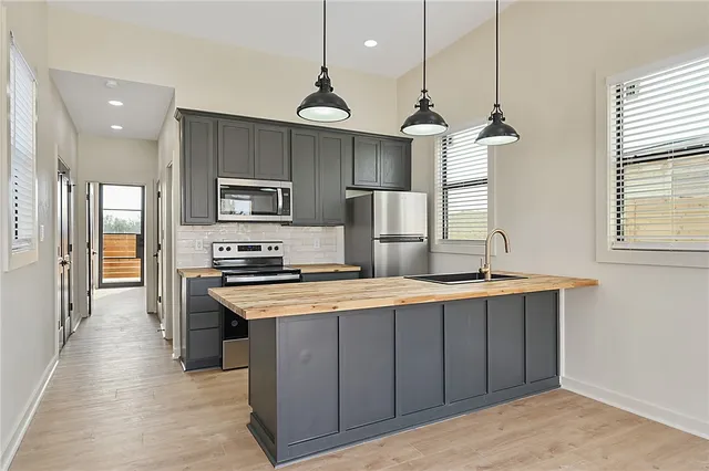 a kitchen with kitchen island a sink stainless steel appliances and window