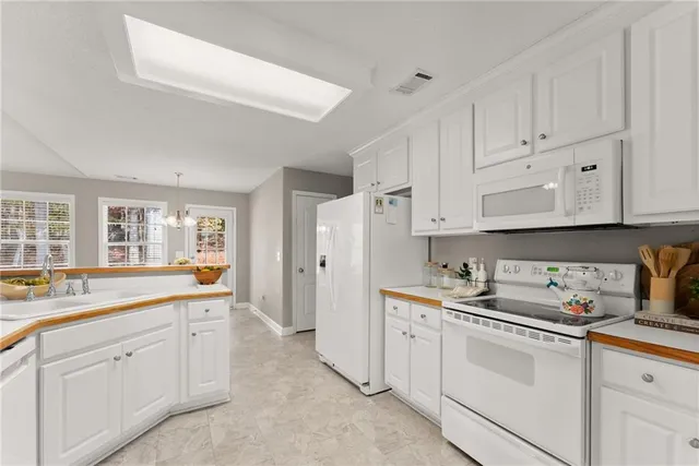 a kitchen with white cabinets and white appliances