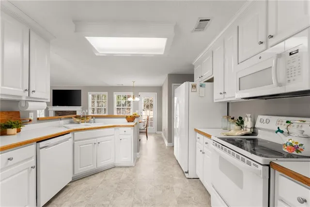a kitchen with white cabinets sink and white appliances