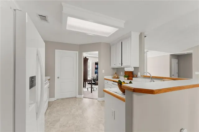 a kitchen with stainless steel appliances granite countertop a sink refrigerator and cabinets