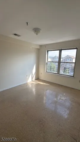 a view of an empty room and chandelier