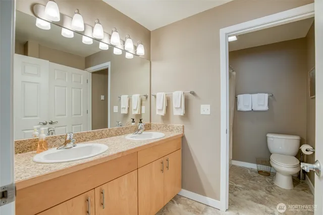 a bathroom with a toilet sink and mirror