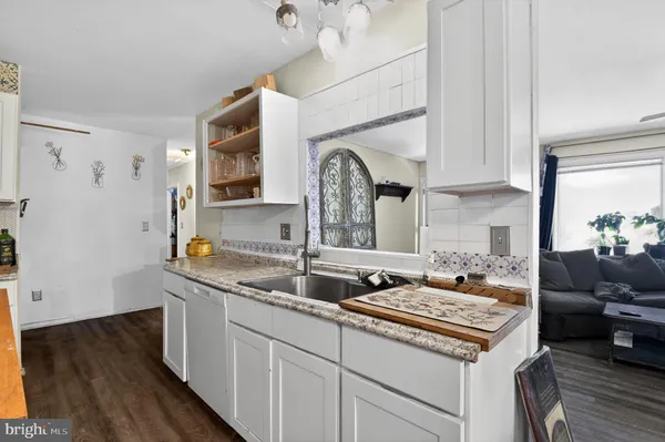 a kitchen with a sink cabinets and wooden floor