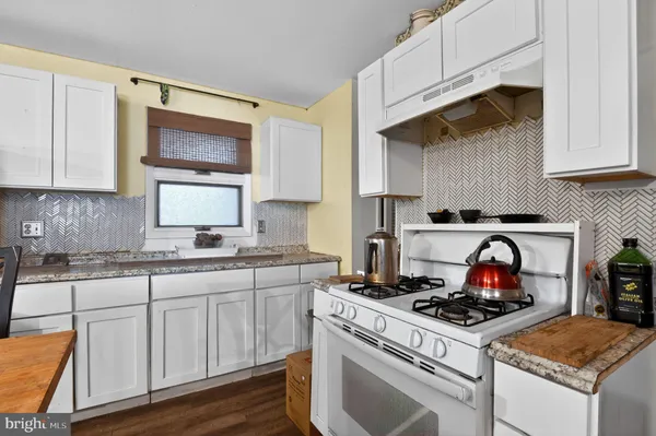 a kitchen with white cabinets and appliances
