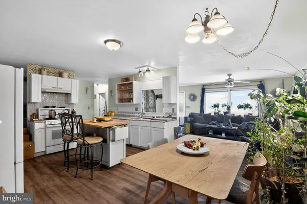 a kitchen with sink refrigerator dining table and chairs