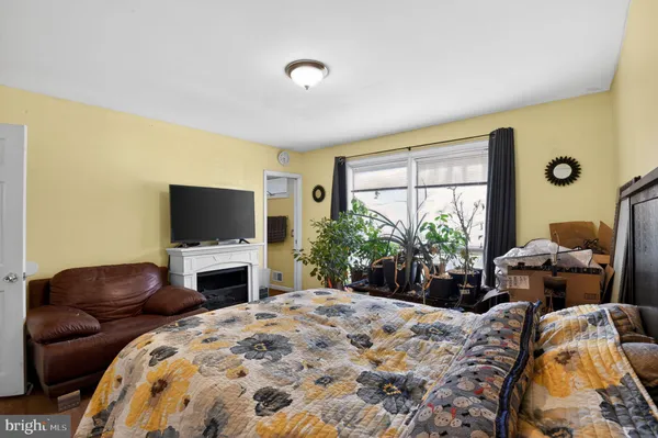 a bedroom with furniture a flat screen tv and a fireplace