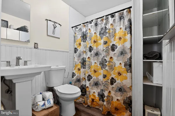 a bathroom with a toilet sink and shower curtain