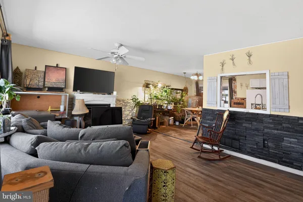 a living room with furniture a flat screen tv and kitchen view