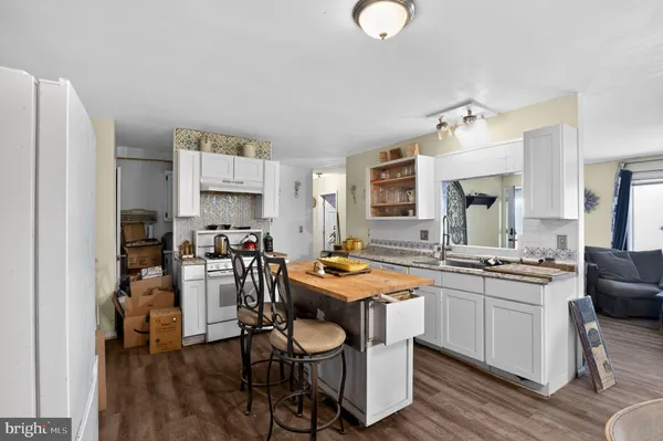 a kitchen with stainless steel appliances granite countertop a stove a sink dishwasher and a refrigerator with wooden floor