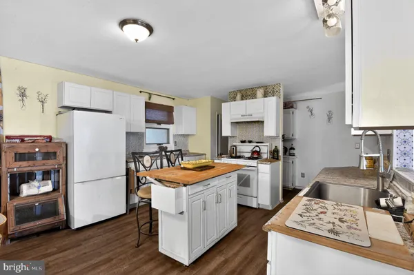 a kitchen with a refrigerator and a stove top oven