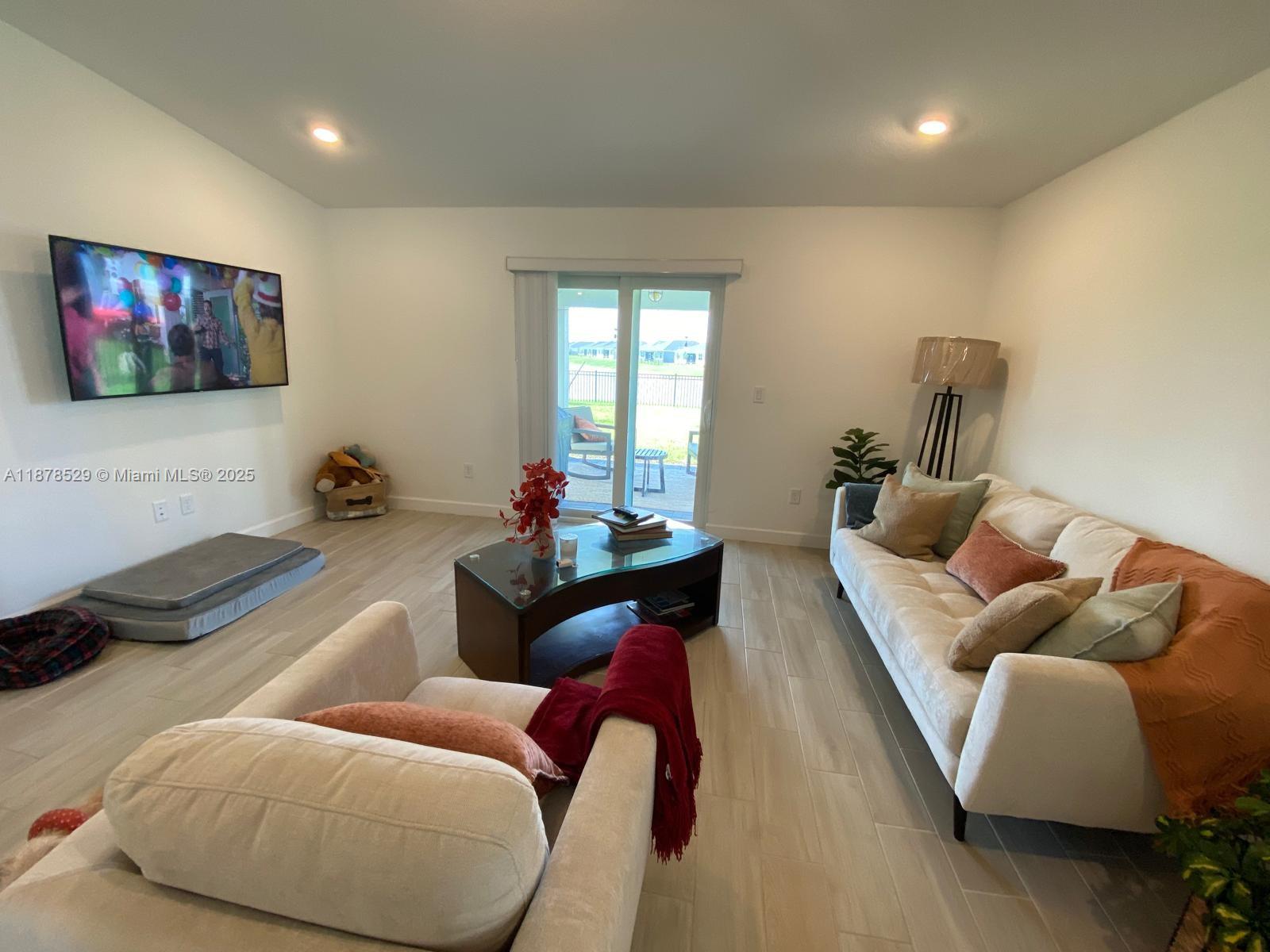 11060 Middle Strm Drive Port St. Lucie, FL 34987 - Photo 11 of 41 a living room with furniture and a flat screen tv