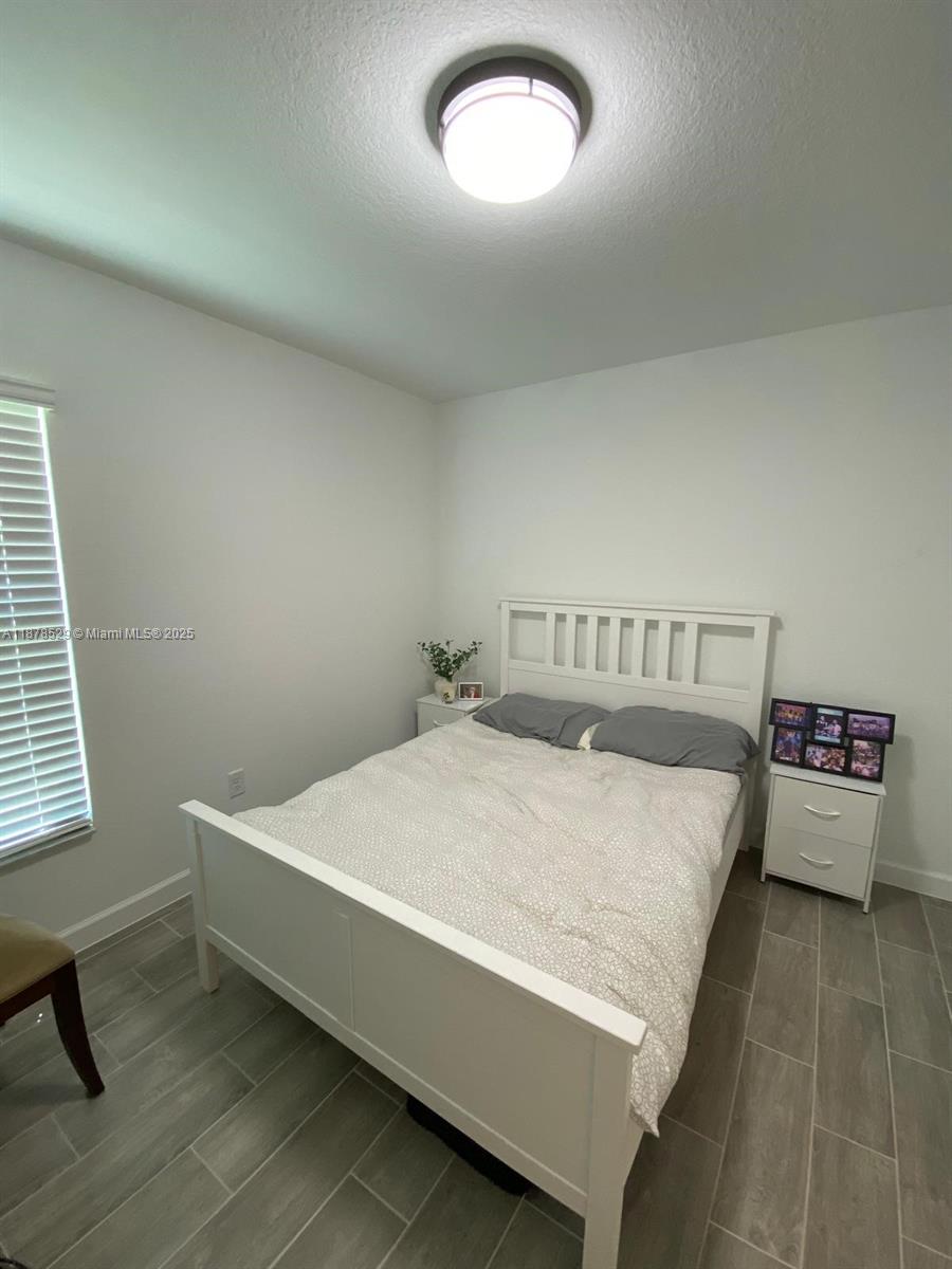 11060 Middle Strm Drive Port St. Lucie, FL 34987 - Photo 17 of 41 a bed sitting in a bedroom next to a window