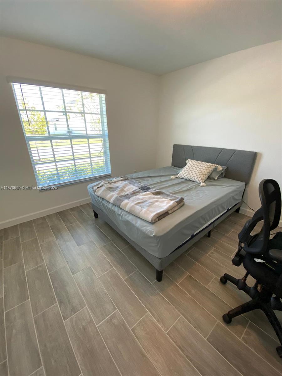 11060 Middle Strm Drive Port St. Lucie, FL 34987 - Photo 23 of 41 a bed sitting in a bedroom next to a window