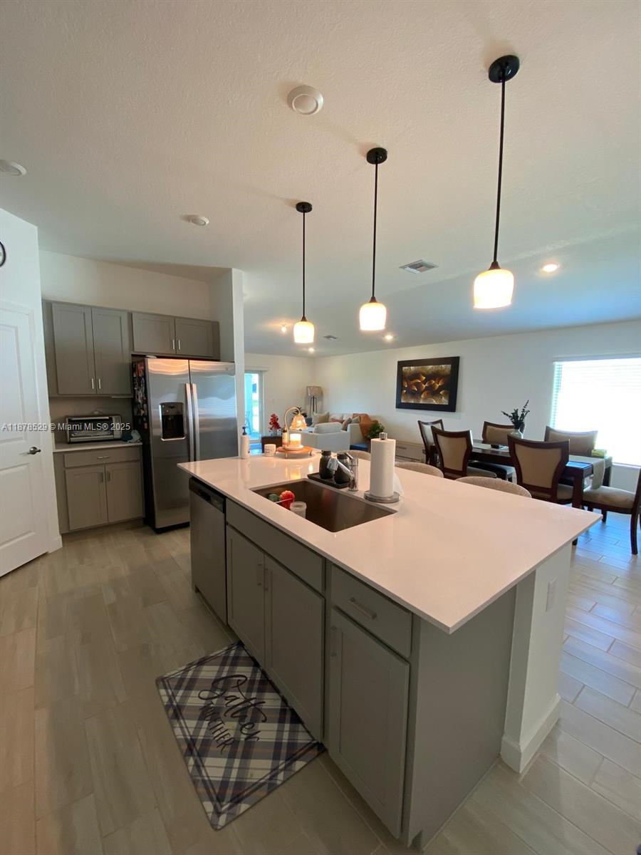 11060 Middle Strm Drive Port St. Lucie, FL 34987 - Photo 30 of 41 a kitchen with stainless steel appliances kitchen island granite countertop a sink counter space cabinets and appliances