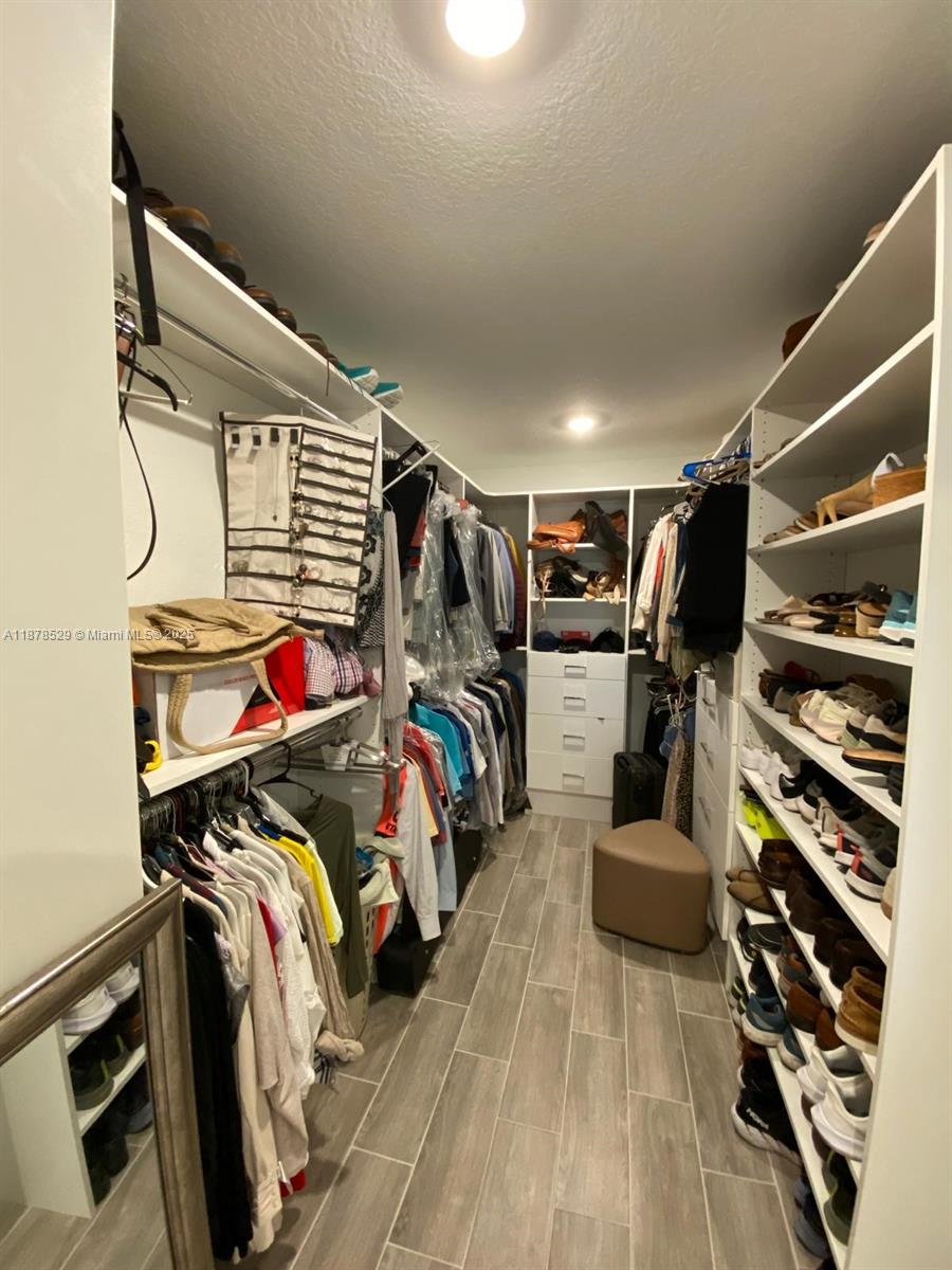 11060 Middle Strm Drive Port St. Lucie, FL 34987 - Photo 31 of 41 a view of walk in closet with clothes and shoes