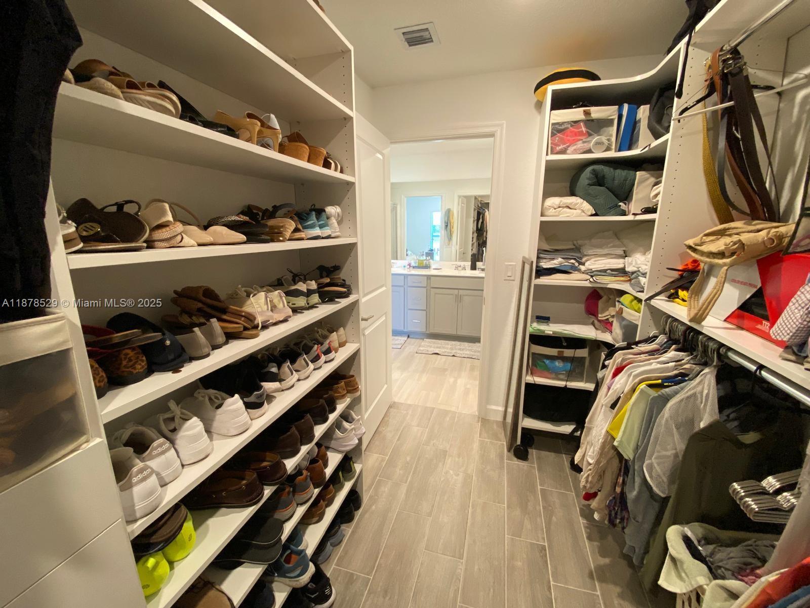 11060 Middle Strm Drive Port St. Lucie, FL 34987 - Photo 32 of 41 a view of walk in closet with clothes and shoes