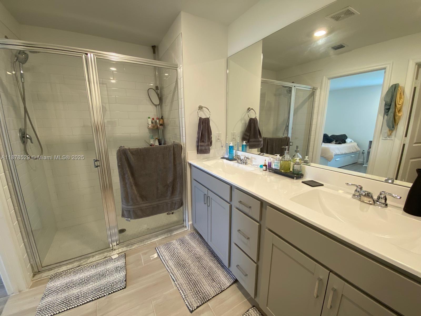 11060 Middle Strm Drive Port St. Lucie, FL 34987 - Photo 35 of 41 a bathroom with a double vanity sink mirror and shower