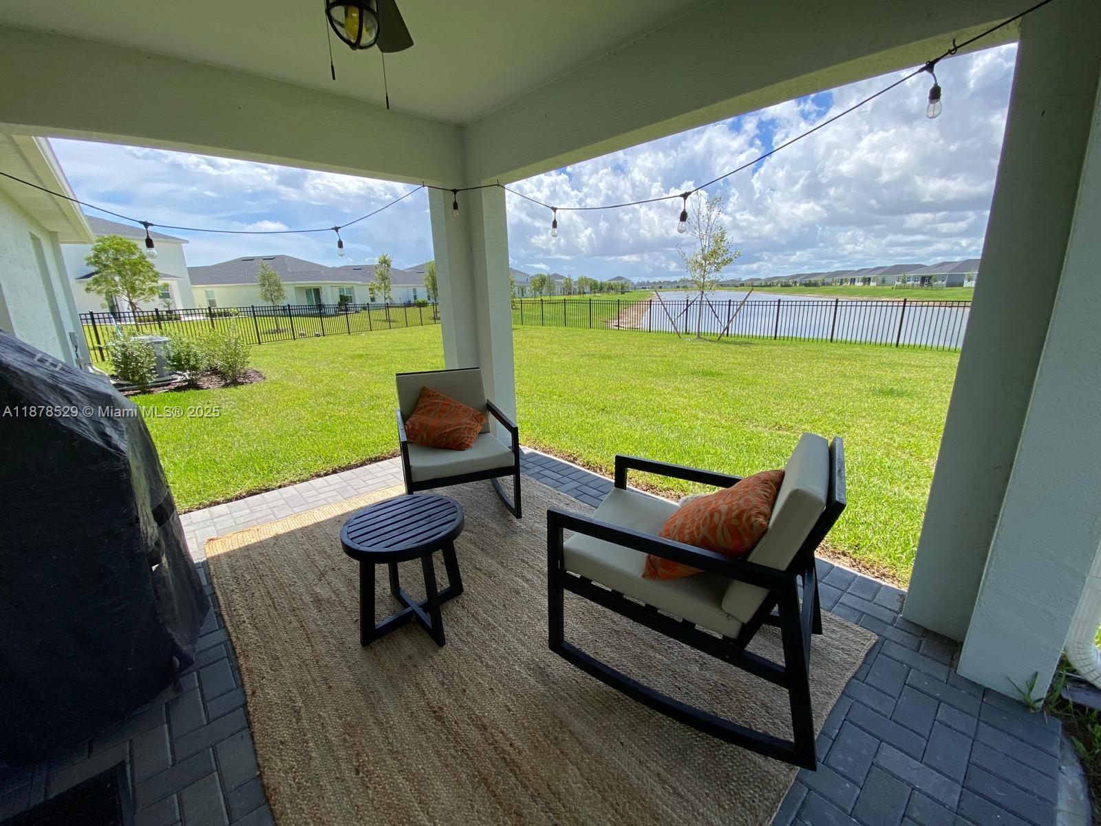 11060 Middle Strm Drive Port St. Lucie, FL 34987 - Photo 6 of 41 a view of a chairs and table in patio with a yard